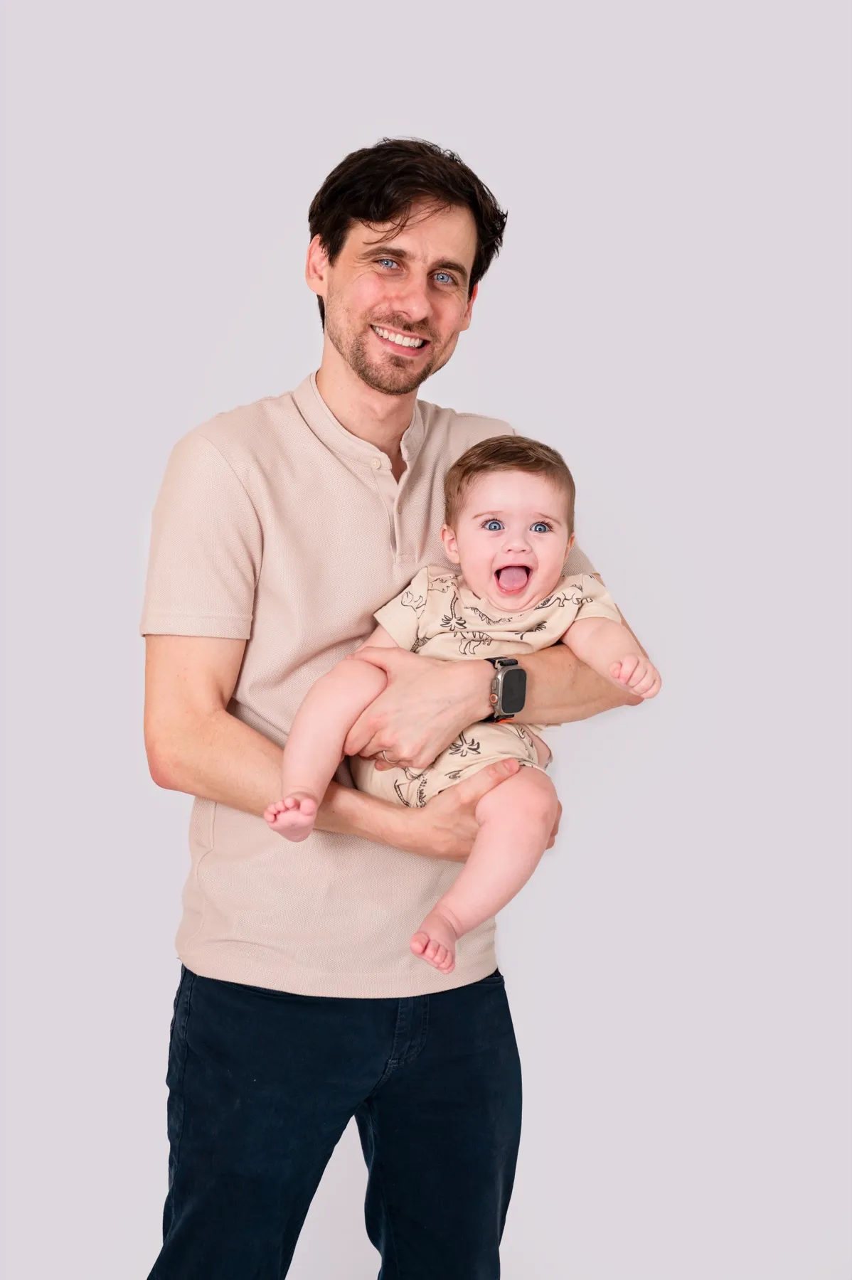 Papá sonriendo con su bebé en brazos