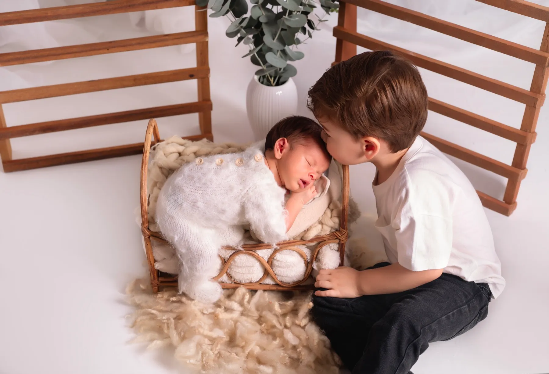 Hermano mayor besando a su hermanito recién nacido