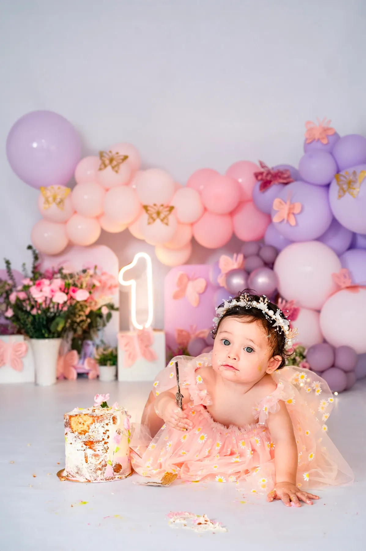 Bebita con globos pastel y mariposas